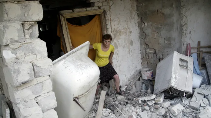 Obyvatelka Doněcku prohlíží trosky svého domu