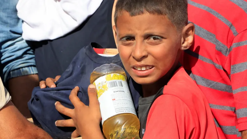 Palestinci vyhledávající základní potraviny nedaleko distribučního střediska Humanitární nadace pro Pásmo Gazy (GHF) (27. května 2025)