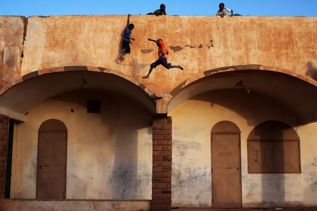 Chlapci si hrají na střeše vchodu fotbalového stadionu v Gao, Mali, 20. února 2013