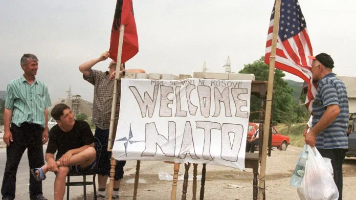 Kosovští Albánci vítají NATO a líbají vlajky USA a Albánie při návratu do vlasti přes makedonsko-kosovskou hranici (15. 6. 1999)