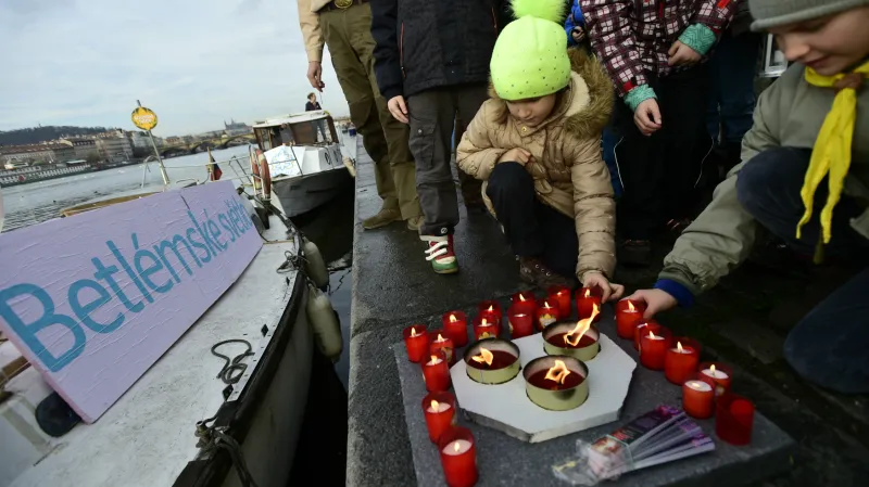 Skauti rozdávají betlémské světlo z lodi zakotvené na Vltavě v Praze.
