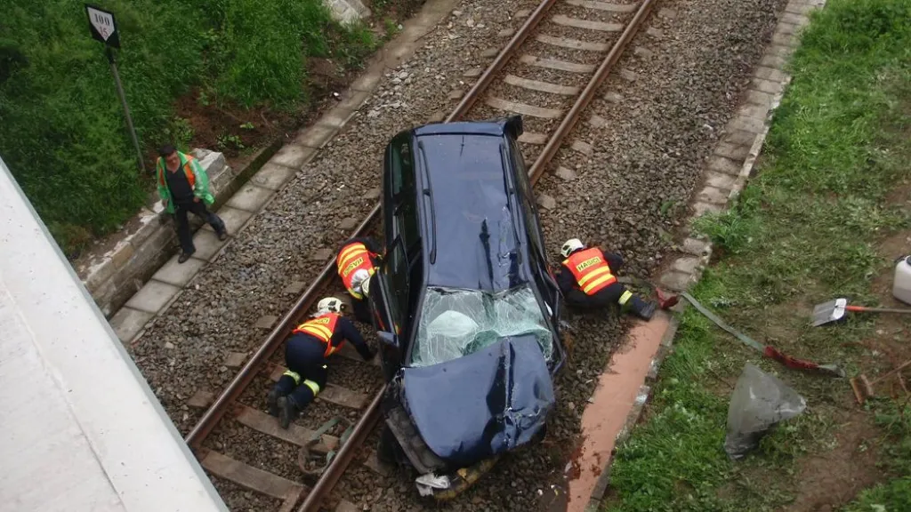 Řidič s autem spadl z mostu do kolejiště