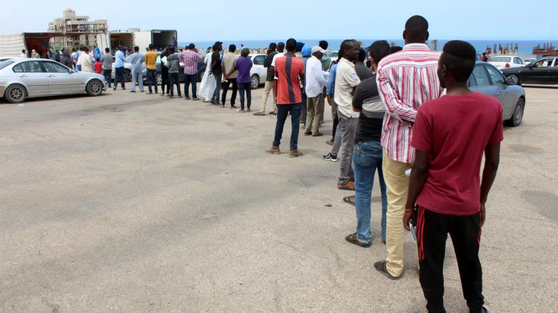 Migranti čekající na potravinové balíčky od UNHCR