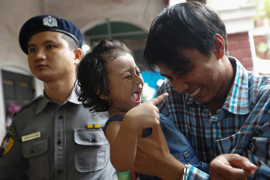 Zadržený novinář agentury Reuters Kyaw Soe Oo při krátkém setkání se svou dcerou během policejní eskorty k soudu v myanmarském Rangúnu.