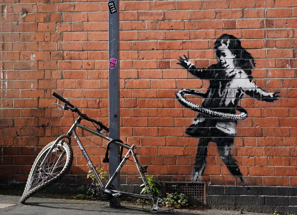 Obrázek hrající si dívky vysvětluje, kam se ztratilo zadní kolo pohozeného bicyklu v jedné z ulic Nottinghamu