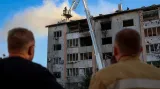 Záchranáři před zničenou budovou