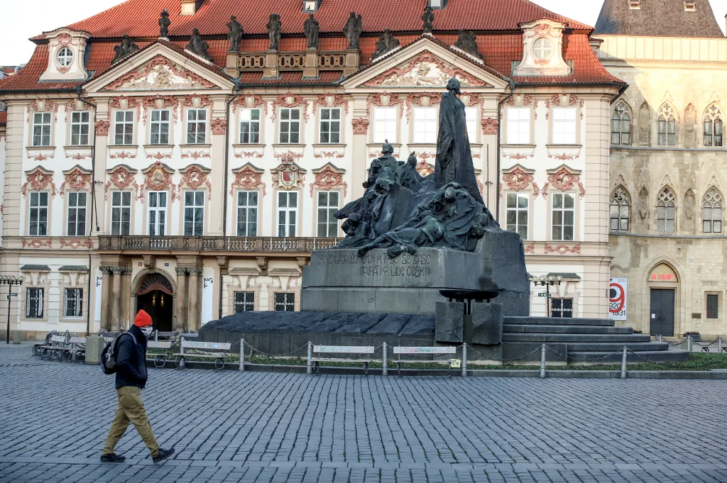 Staroměstské náměstí v současnosti nezaplavují tisíce turistů. Pokud se zde někdo objeví, chrání si obličej