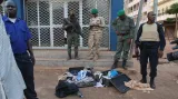 Malijští vojáci ukazují granáty a osobní věci atentátníků