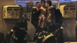 Pařížští hasiči pomáhají zraněnému civilistovi v šoku bezprostředně po útoku v koncertním sále klubu Bataclan, který si vyžádal nejvíce obětí na životech. Do budovy kolem 21:40 SEČ pronikli tři útočníci vyzbrojení útočnými puškami AK-47 a ručními granáty. Zabili desítky lidí a další desítky osob vzali jako rukojmí.