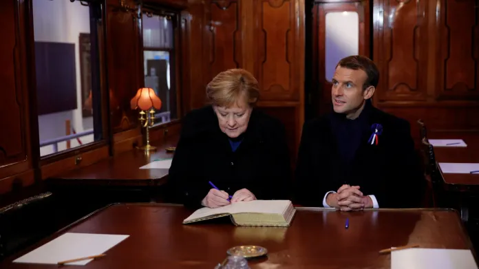 Emmanuel Macron a Angela Merkelová se zapsali do návštěvní knihy v replice vagonu, kde bylo podepsáno příměří v roce 1918