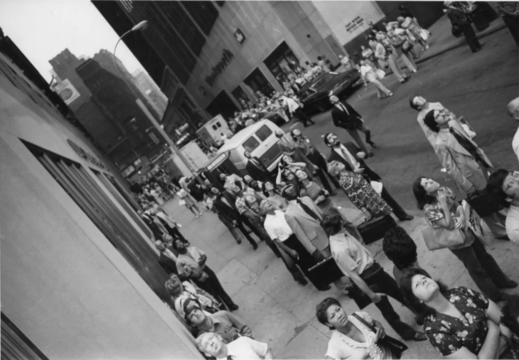 Lídé se ráno zastavují v ulicích pod Světovým obchodním centrem a sledují, co se děje 400 metrů nad nimi
