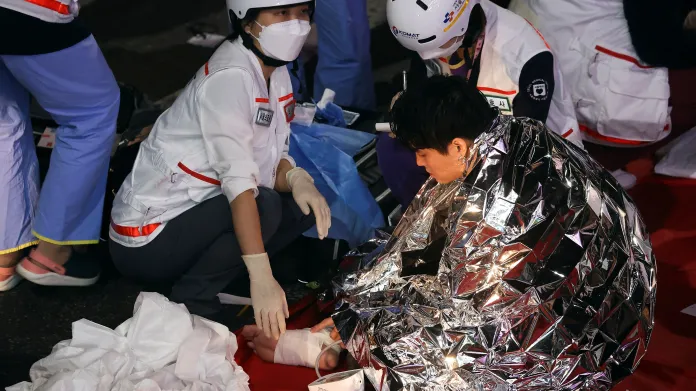Zdravotníci ošetřují lidi zraněné v tlačenici při oslavách Halloweenu v Soulu
