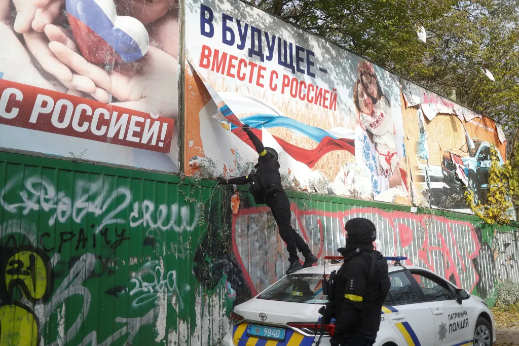 Ukrajinci sundavají plakát v Chersonu s nápisem „Do budoucnosti spolu s Ruskem“