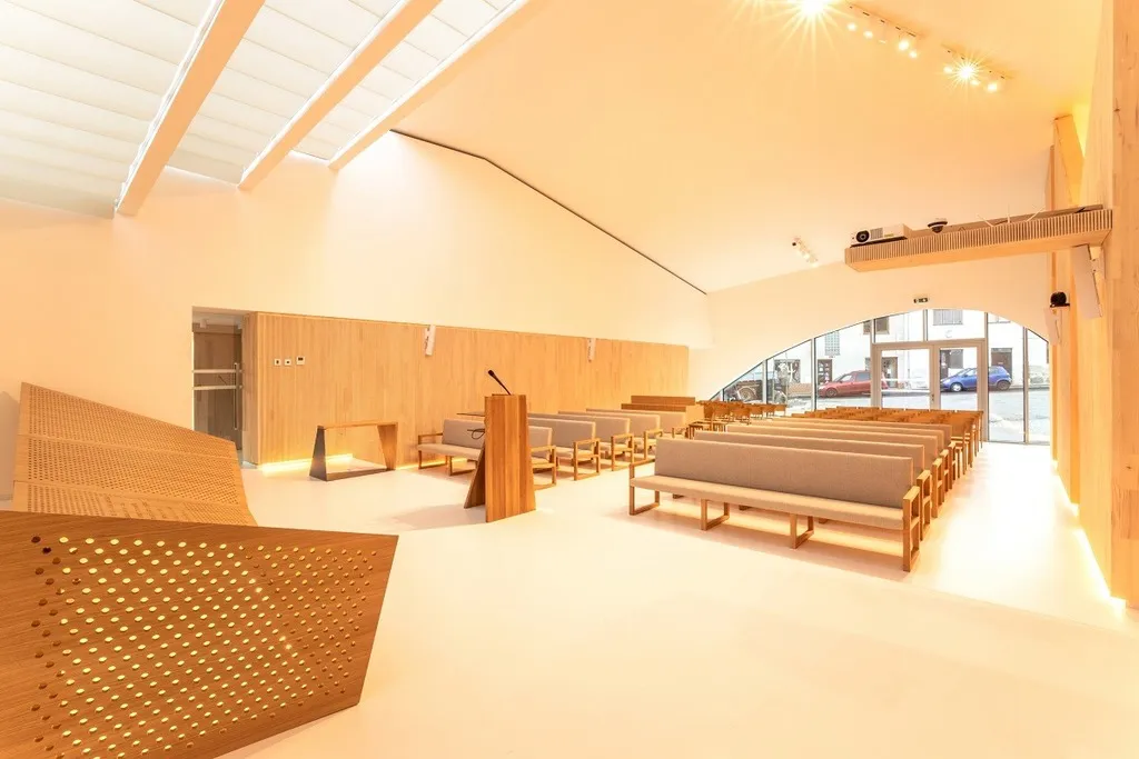 Společenské centrum tvoří soubor dvou staveb: střízlivěji pojaté bytové části a architektonicky expresivní modlitebny