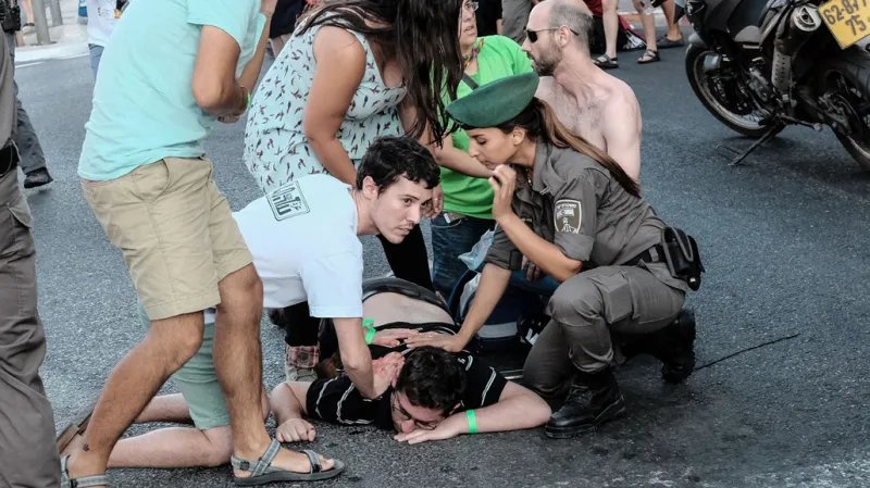 Lidé pomáhají jednomu ze zraněných