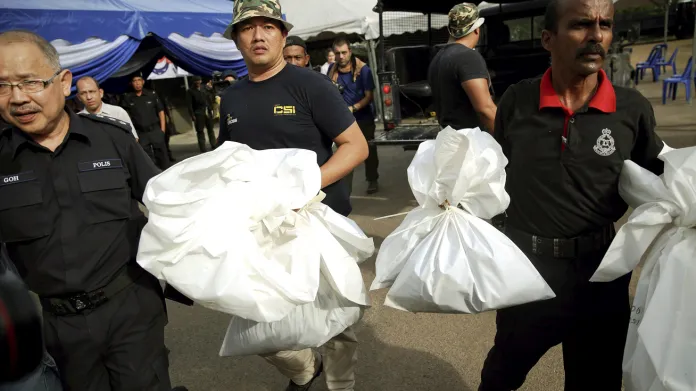 Malajsijská policie odváží těla z hrobů nalezených v džungli u hranic s Thajskem