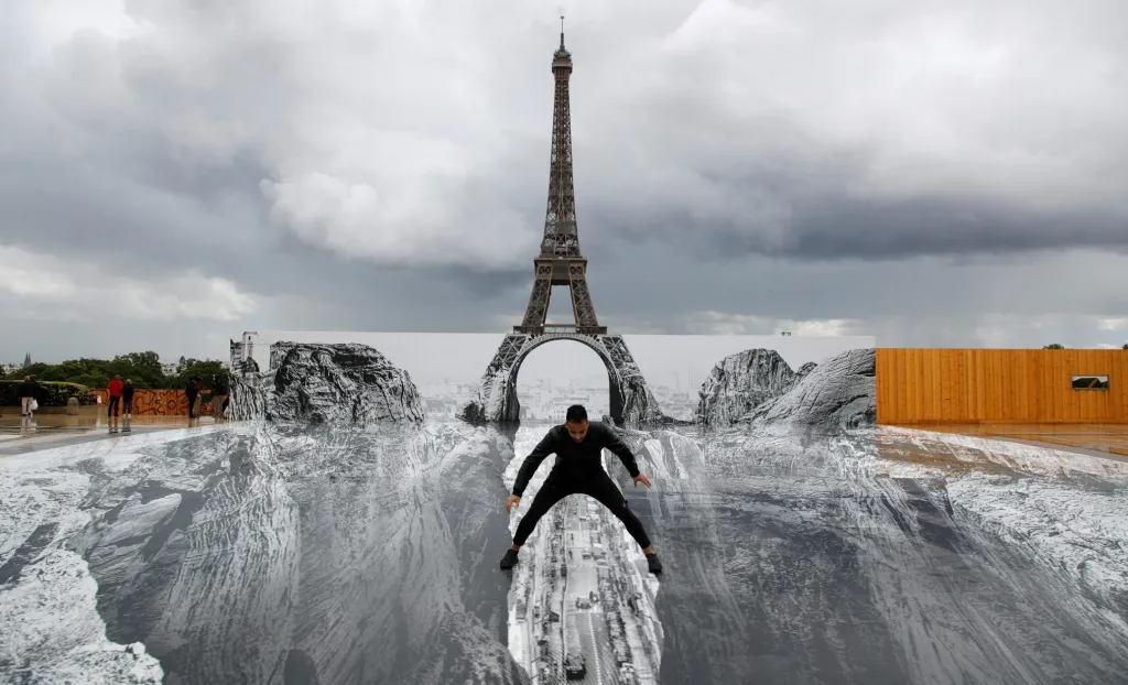 Obří díra před Eiffelovou věží je výsledkem díla francouzského umělce, který si říká JR