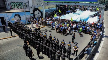 Příslušníci policie a námořní prefektury střeží demonstranty shromážděné u mostu Pueyrredon