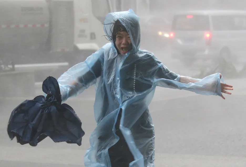 Vystrašená žena utíká před přívaly větru tajfunu Mangkhut v čínském městě Šen-čen