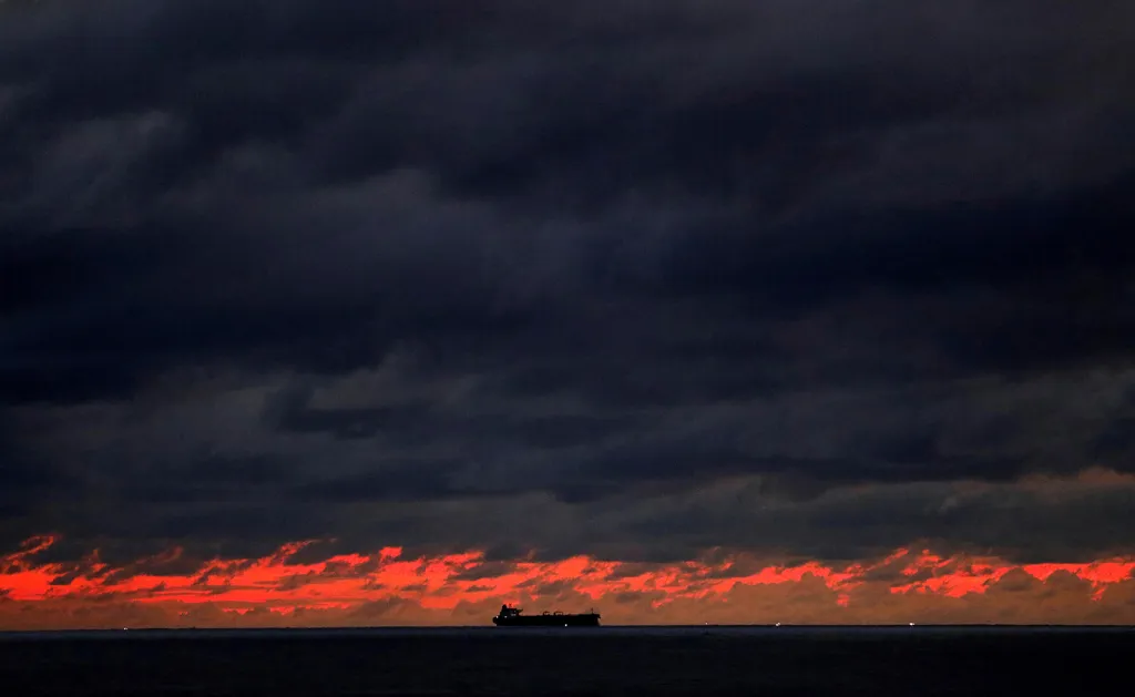 Námořní loď míří k přístavu Kolombo pod těžkými dešťovými mraky při západu slunce nedaleko pevnosti Galle Fort na Srí Lance.