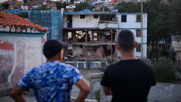 Obyvatelé venezuelského města Catia La Mar pozorují bytový dům, poničený během amerického útoku na Venezuelu