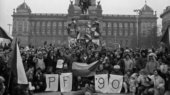 Atmosféra lstopadového týdne (20.-27.11.1989) v Praze. Lidé ukazují znak vítězství (véčko) a pózují s nápisem PF 90 během demonstrace na Václavském náměstí.