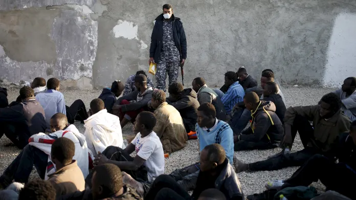 Policista v Tripolisu dohlíží na nelegální migranty