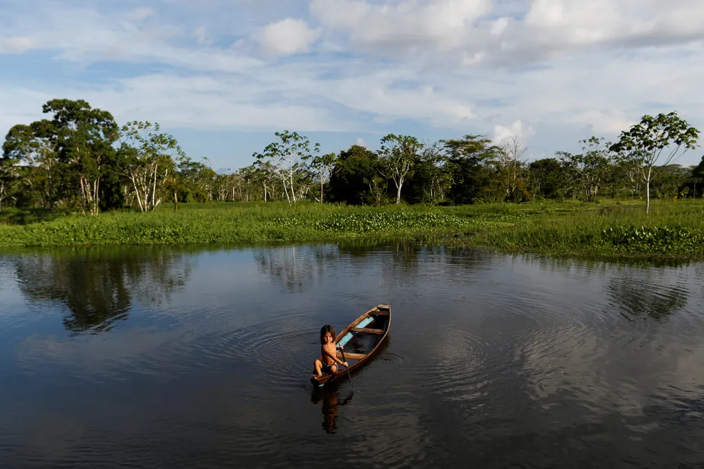 Dítě pádluje svůj člun v odlehlé rezervaci Mamiraua Sustainable Development Reserve v Amazonii