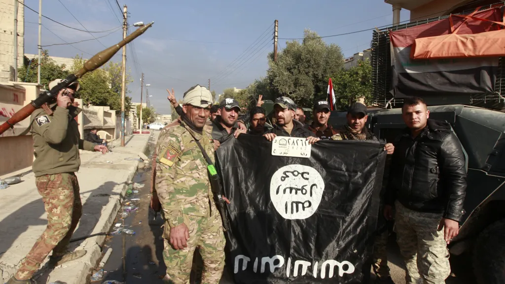 Irácké síly drží strženou vlajku Islámského státu po boji v jedné ze čtvrtí Mosulu