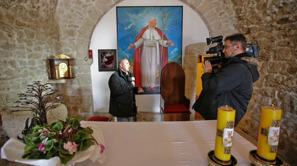 Reportér před rozbitou vitrínou, odkud ukradli relikvii s krví Jana Pavla II.