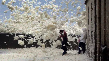 Rodina chránící se před bouří Eleanor a poryvy silného větru na pobřeží zpěněného moře nedaleko francouzského města Saint-Guenole.