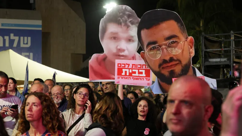 Lidé drží papírové výstřižky mrtvých rukojmích Ran Gviliho a Sudthisaka Rinthalaka na demonstraci za jejich navrácení. Tel Aviv, Izrael, 29. listopadu 2025