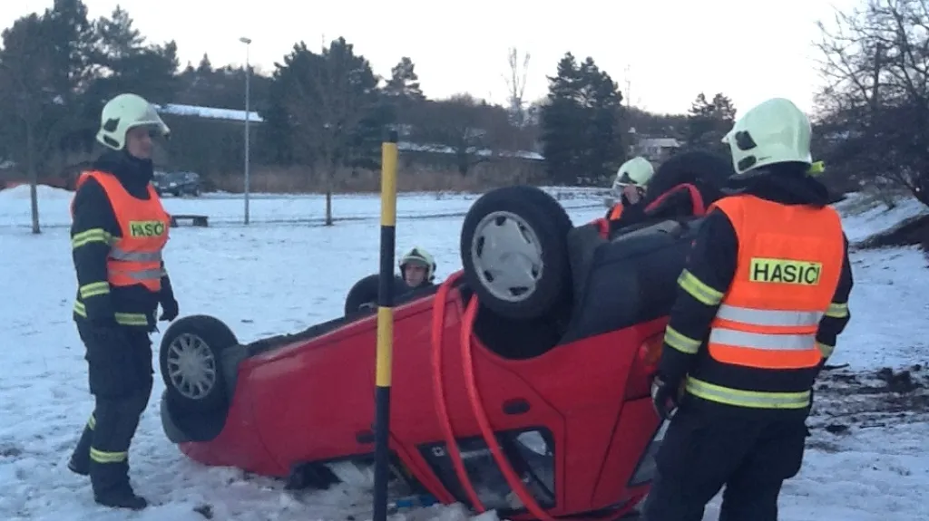 Hasiči pomáhají dostat auto na kola
