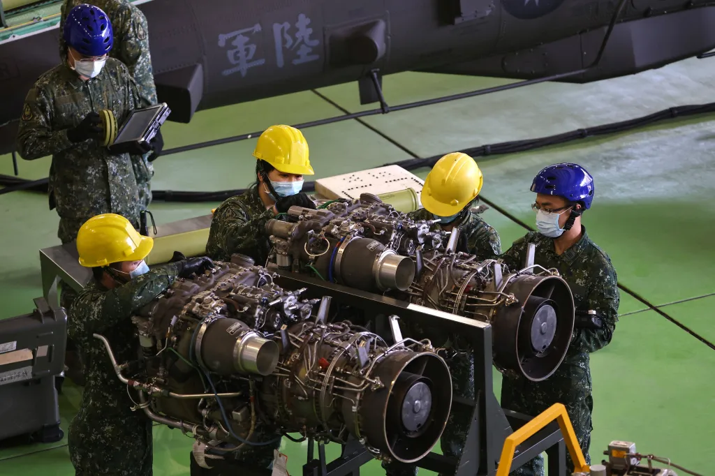 Na vojenské základně v Tchaj-nanu na Tchaj-wanu předvádějí důstojníci letectva údržbu motoru útočného vrtulníku AH-64 Apache.