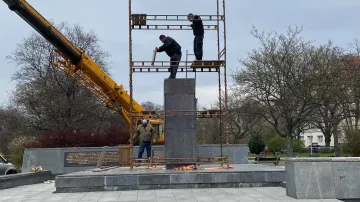 Dělníci na lešení kolem prázdného podstavce Koněvovy sochy