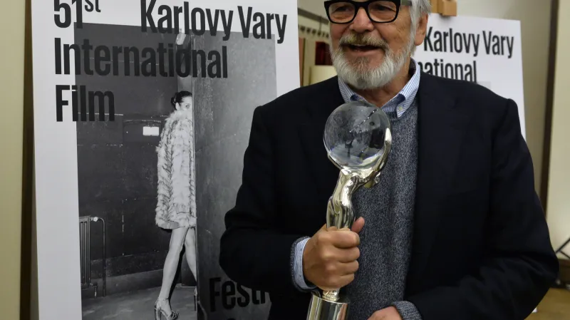 Prezident festivalu Jiří Bartoška před plakátem 51. ročníku