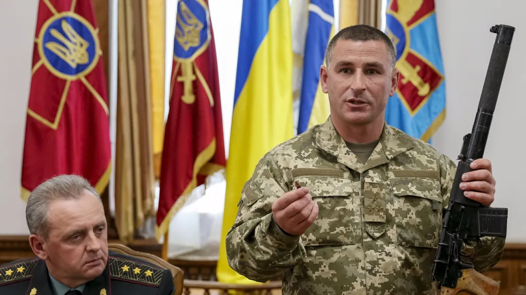 Ukrajinský důstojník ukazuje zbraň zabavenou zadrženým ruským vojákům