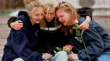 21. dubna 1999. Rachel Ruth, Rhianna Cheek a Mandi Annibel, šestnáctileté studentky druhého ročníku, oplakávají své spolužáky a učitele během mše na uctění památky obětí.