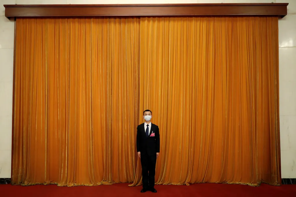 V Pekingu zasedá Všečínské shromáždění lidových zástupců, což je tamní obdoba parlamentu. U opony stojí muž, který má na starosti vítání jednotlivých zástupců