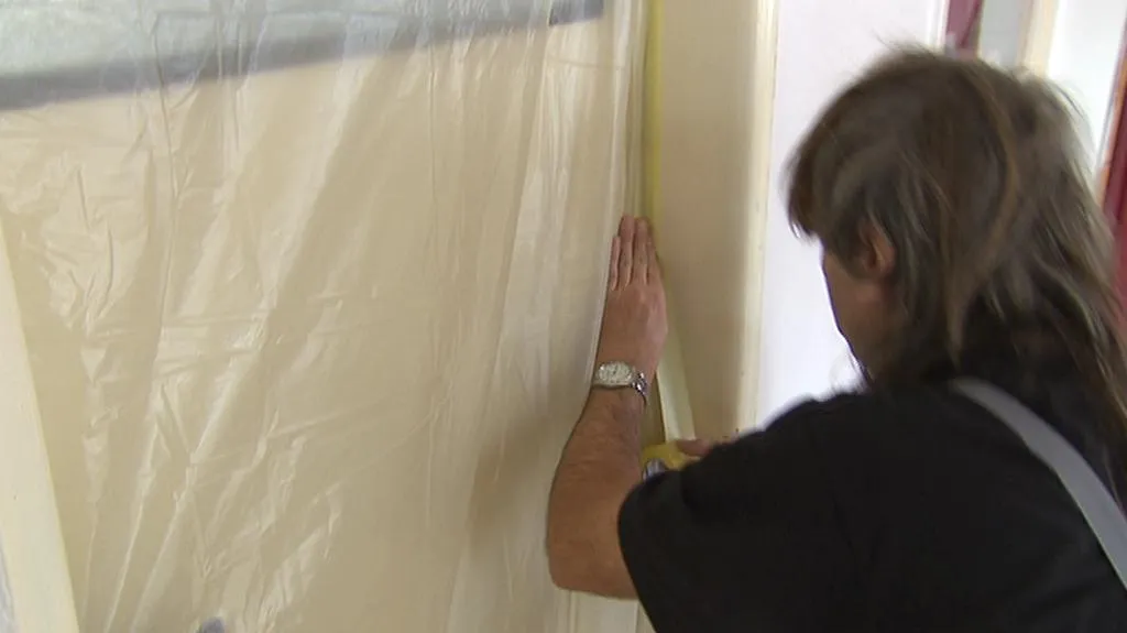 Pracovník utěsňuje dveře před únikem azbestu