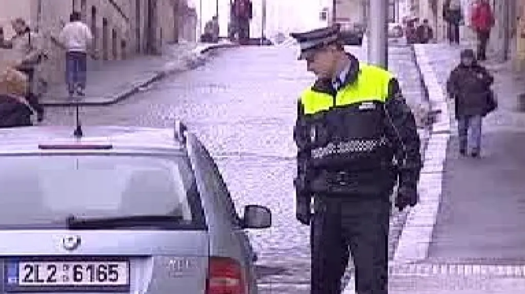 Strážník kontroluje zaparkované auto