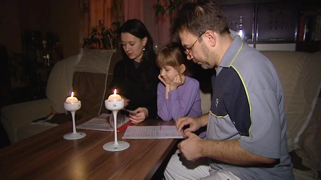 Rodina Andreje Jegošina kontroluje účty při světle svíček