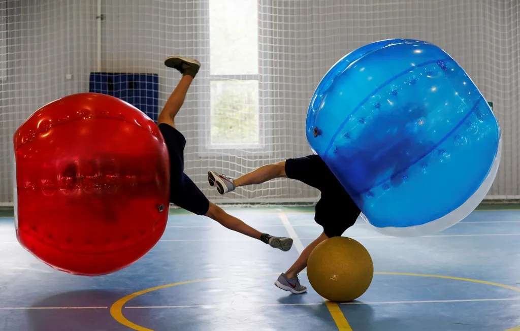 Školní děti v Moskvě při hře zvané „bumper ball“, v níž jsou hráči fotbalu nasoukáni do obřích nafukovacích míčů