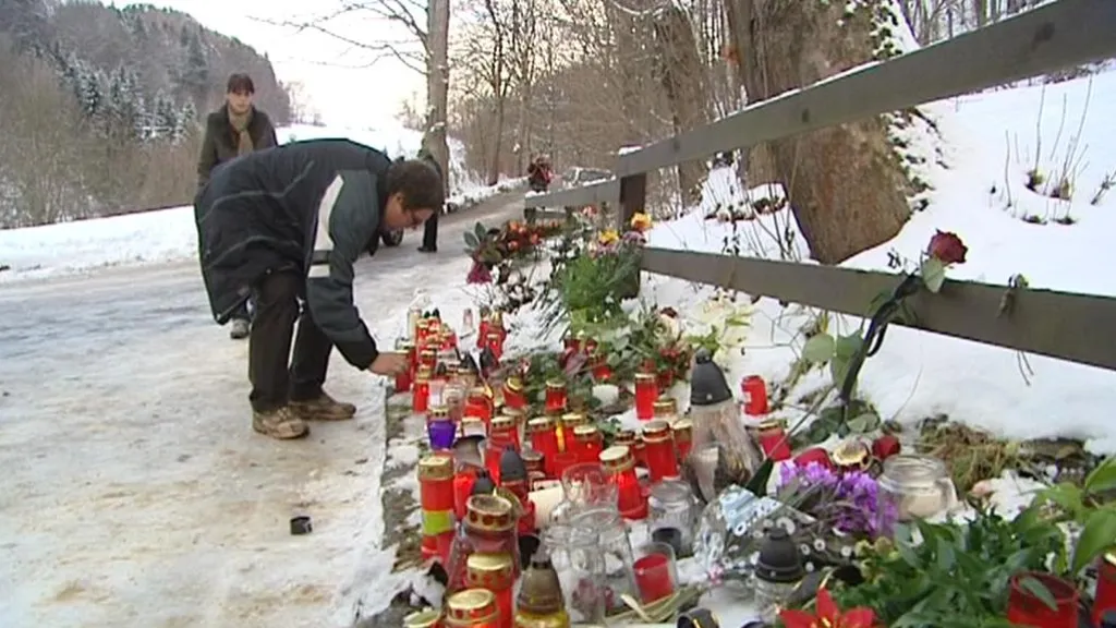 Lidé pokládají svíčky před plot chalupy na Hrádečku