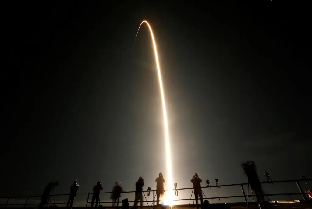 Návštěvníci mysu Canaveral na Floridě v USA sledují, jak raketa SpaceX Falcon 9 s modulem Crew Dragon vzlétá se čtyřmi astronauty na palubě