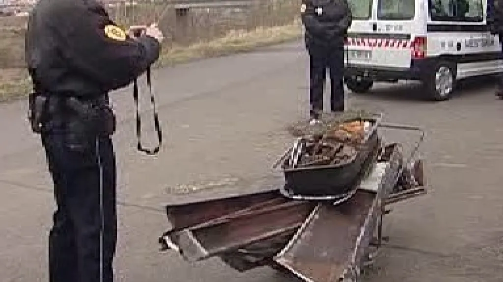 Policista při dokumentaci kovového odpadu