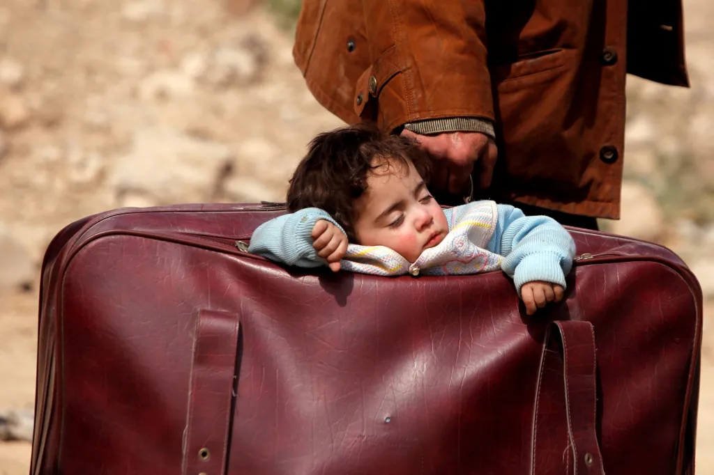 Dítě uprchlíků během jejich návratu usnulo kousek od vesnice Beit Sawa v syrské Ghútě. Foto z 15.března 2018