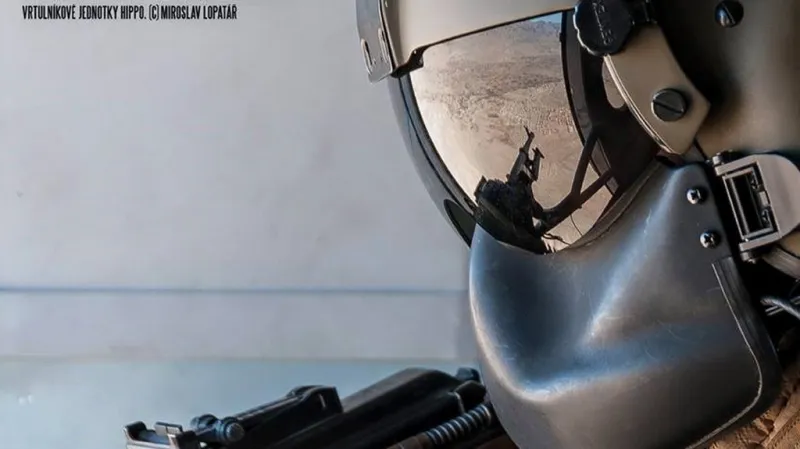 Odraz afghánské vesnice na ochranné masce palubního střelce vrtulníkové jednotky HIPPO