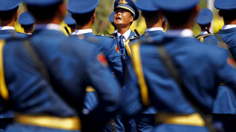 Čínsky důstojník dává povely vojákům během nácviku na vojenskou přehlídku