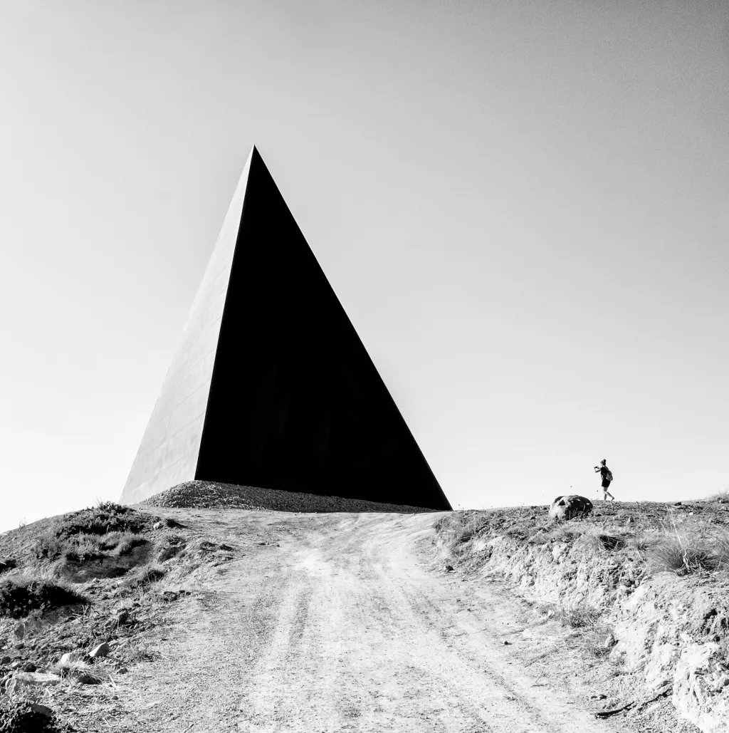 Vítěz kategorie ARCHITECTURE: Emotional Geography. Černobílá fotka zobrazuje 38° Parallelo, pyramidovou stavbu sochaře Maura Staccioliho, stojící na místě, kde se geografické souřadnice dotýkají 38. rovnoběžky